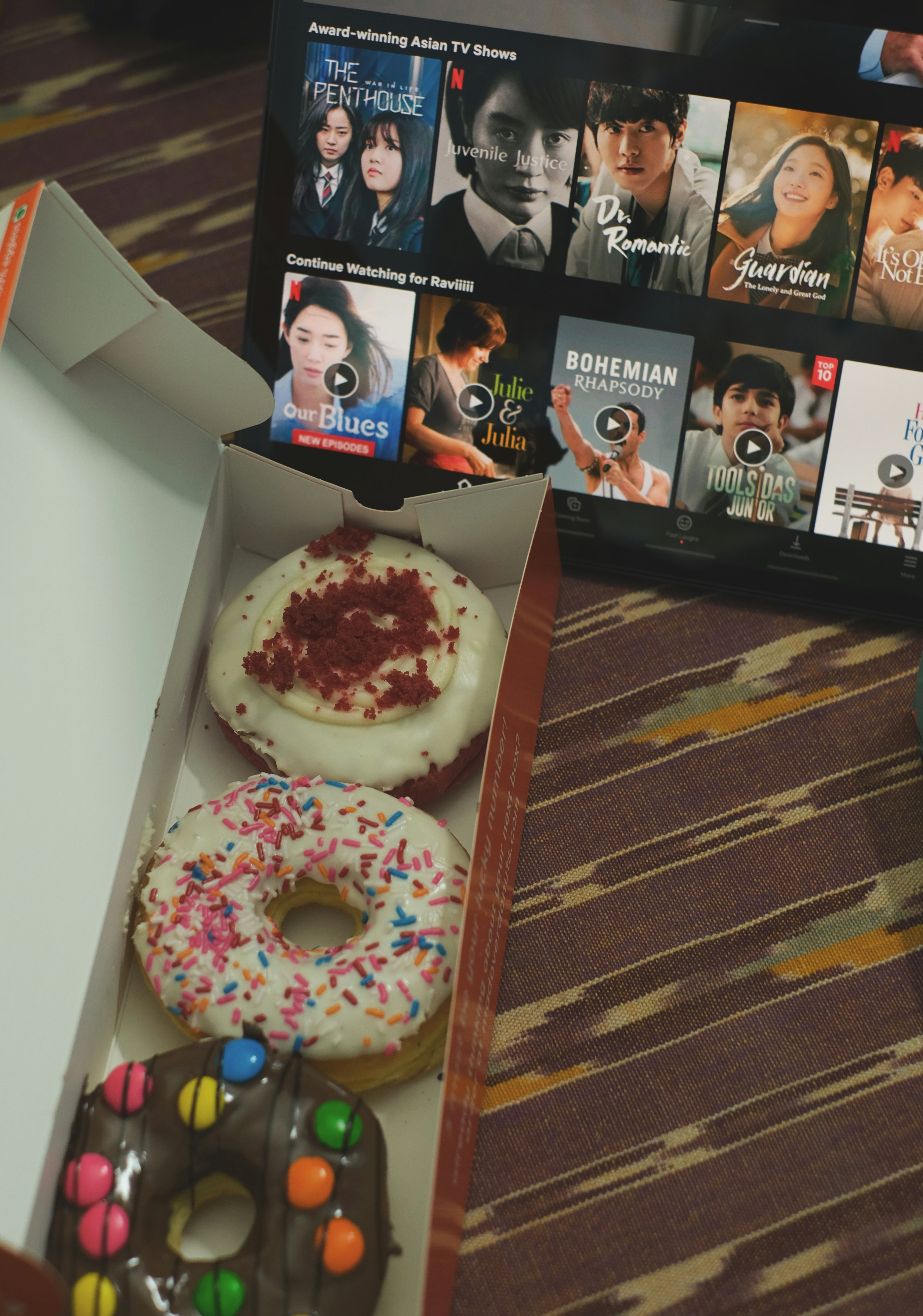 Tablet showing Netflix Korean dramas with donuts in the foreground